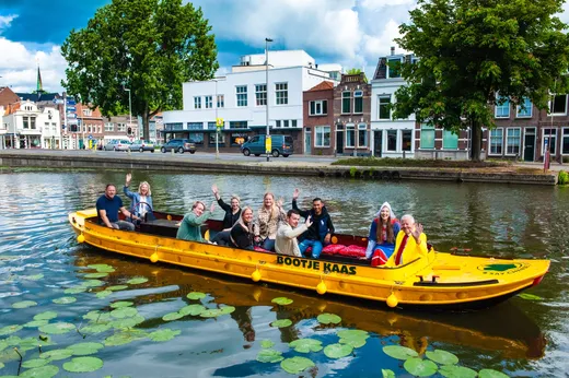 Bootje Kaas rondvaart boot met mensen die zwaaien naar de camera